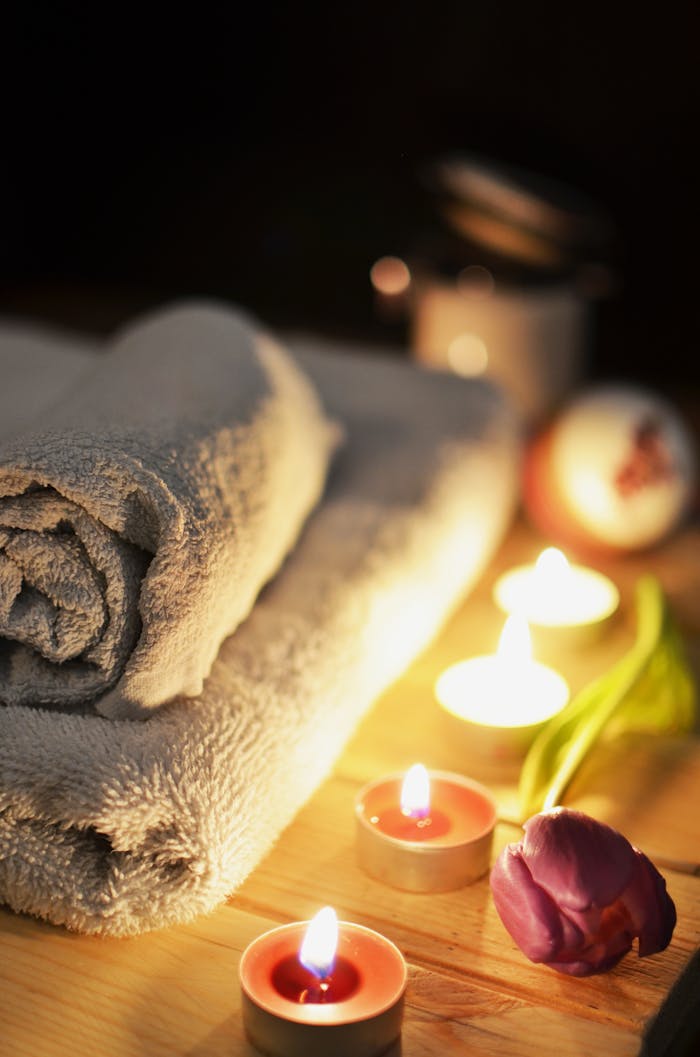 our-services-3 Relaxing spa atmosphere with candles, towels, and a tulip, perfect for wellness and self-care.